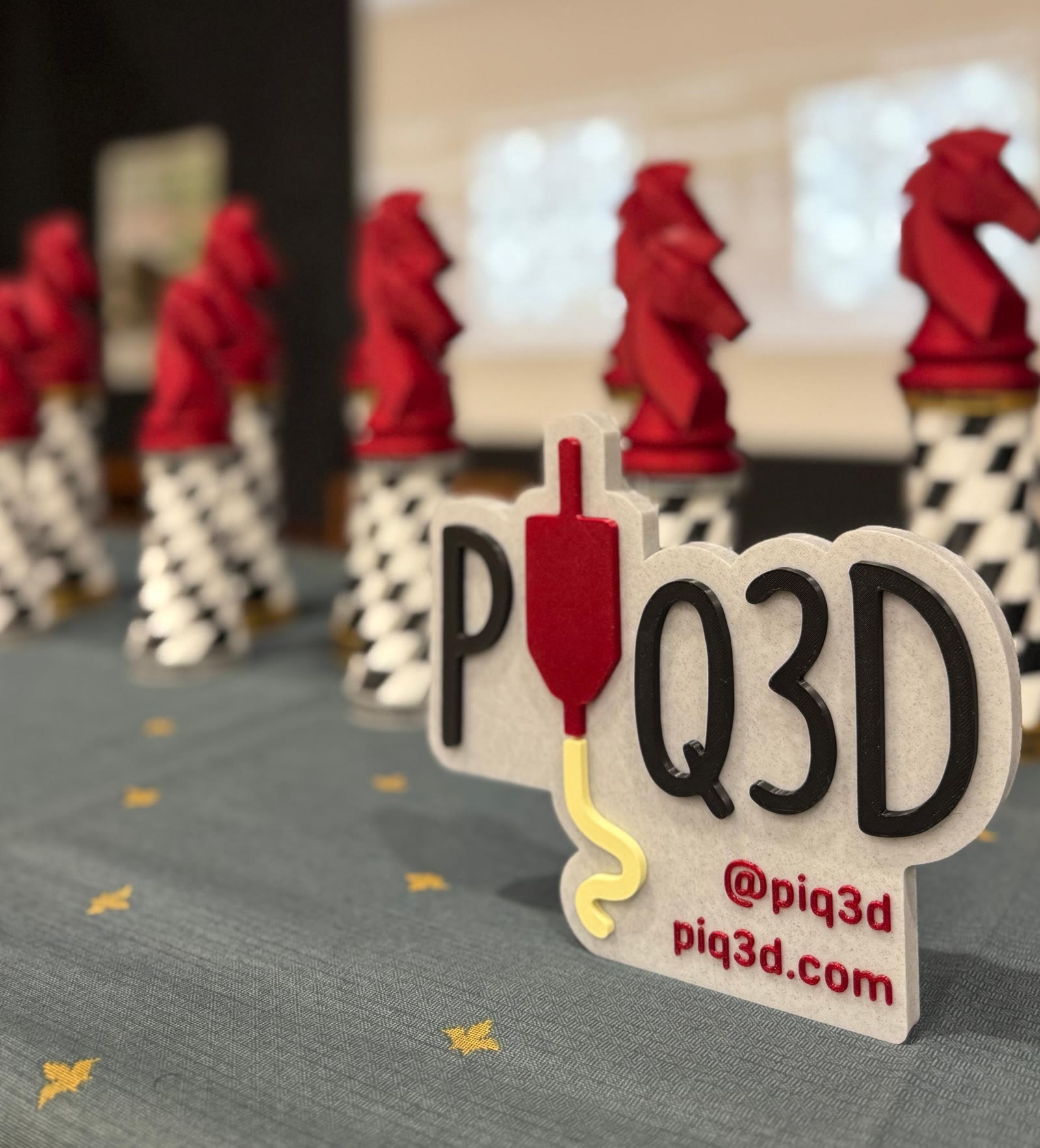 Piezas de ajedrez impresas en 3D junto al logo de PIQ3D